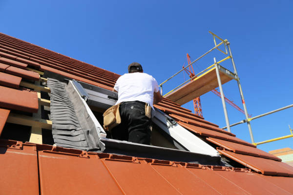 Couvreur professionnel intervenant en urgence sur le toit pour une étanchéité de Velux défectueuse